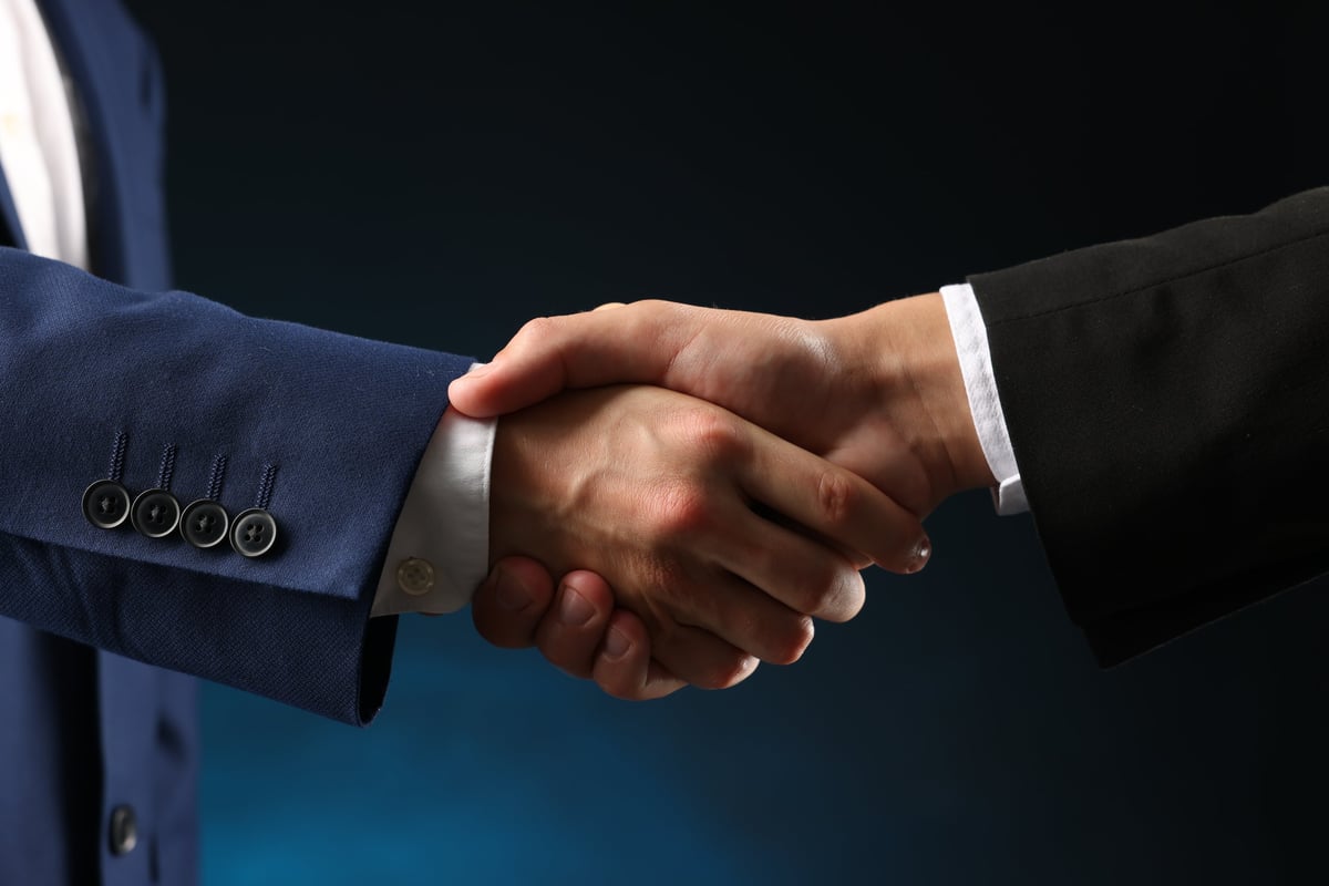 Business partners shaking hands - regulatory compliance and trusted partnerships